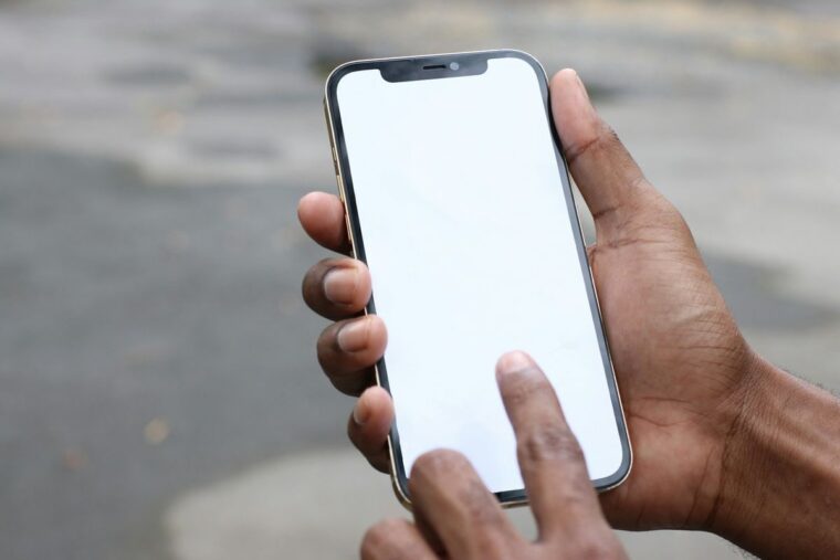 スマートフォンを手に持って画面を操作する手元